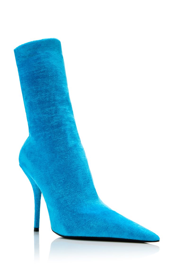 single bright blue velvet sock boot is displayed against a white background.  the boot has a pointed toe and a stiletto heel. the material appears to be a soft, plush velvet. the boot is presented in a clean, studiostyle image emphasizing its shape and color.