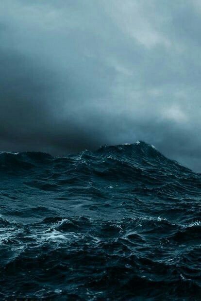 a stormy sea scene with dark blue waves crashing under a moody sky filled with dark clouds. the water is choppy and turbulent, with white foam cresting on the waves. the overall tone is dark and dramatic.