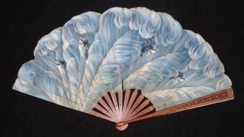 a vintage folding fan with a light blue and white wavy pattern resembling feathers or stylized waves, featuring subtle blue birdlike decorations. the base is a fan structure with radiating wooden sticks and a decorative redbrown rim. the fan is set against a black background.