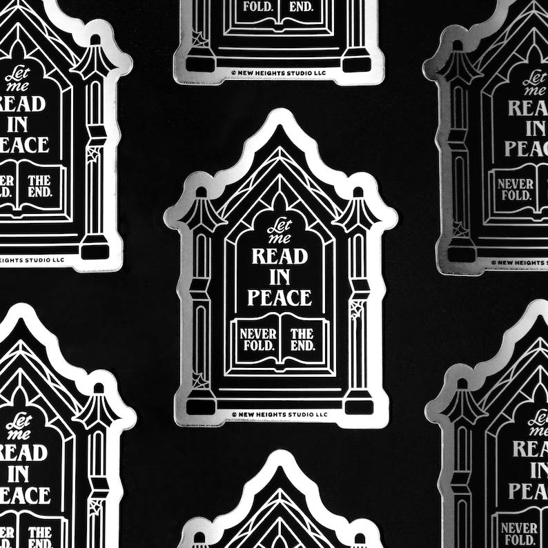 he image shows multiple silver metallic stickers with a gothic design. each sticker depicts a small houselike structure with the phrase "let me read in peace" prominently displayed.  the design includes a book with "never fold" and "the end" written on it. the background is black, and the stickers are arranged in an overlapping pattern.  the "new heights studio llc" copyright is visible on some of the stickers.