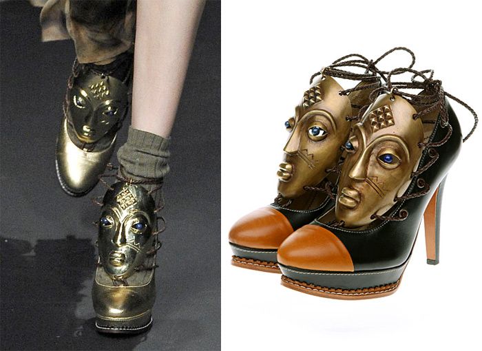 the image is a split view showing two different perspectives of unique highheeled shoes.  the left side displays a model's legs showcasing a pair of goldcolored platform shoes with sculpted gold masklike embellishments on the front, featuring blue eyes.  the right side shows a closeup of another pair of similar design shoes, which have a black and tan leather base and golden masks, each with detailed features and blue eyes, attached to the vamp. both shoes are tied with laces going around the ankle. the style is highly artistic and avantgarde, likely runway or highfashion.