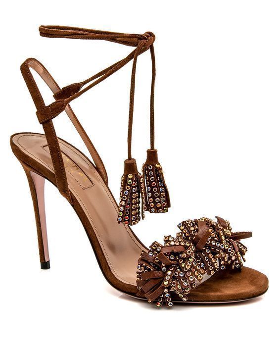 the image shows a pair of brown suede high heels with ankle straps and tassels. the tassels are embellished with crystals. the shoes are elegant and stylish, suitable for evening wear or special occasions. the background is simple and white, focusing the attention on the shoes.