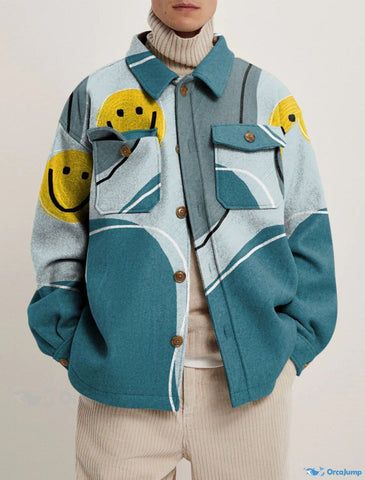 a man is wearing a blue and turquoise jacket with a white smile print and a beige corduroy pant. he is looking at the camera.  the jacket has a button closure and long sleeves.  the model is standing in a casual pose with a relaxed expression.