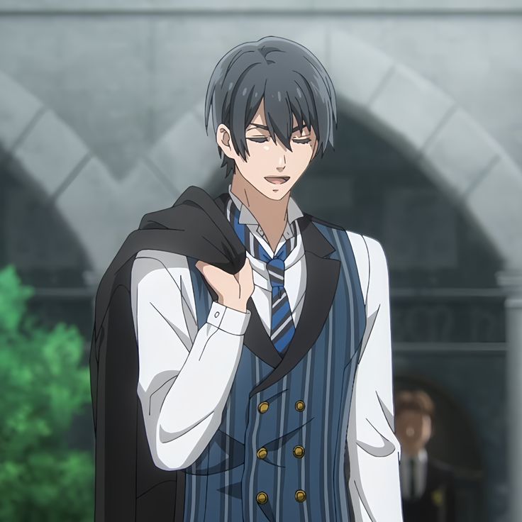 the image shows an anime boy in a suit. he is wearing a dark blue vest with white stripes, a white shirt, and a blue striped tie. he is smiling slightly and looking down, holding a black coat over his arm. the background is blurry, but it appears to be a building with an arched doorway.