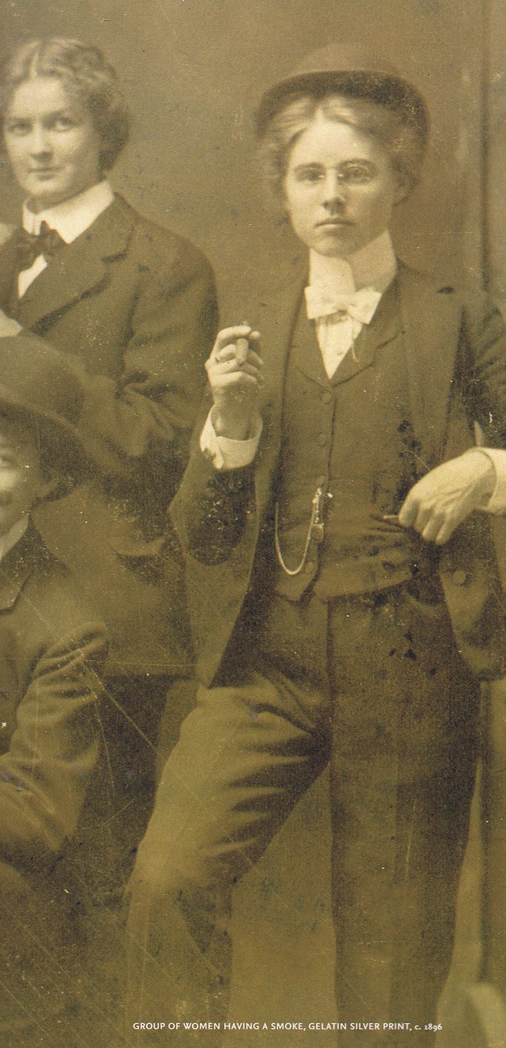 a vintage photograph of a group of women, likely from the early 20th century, smoking cigars or cigarettes. they are all dressed in suits and hats, which were fashionable for women at the time. the woman in the center of the image is holding a cigar in her hand and looking directly at the camera. the photo is a testament to women's changing roles and social norms in the early 20th century, including the growing acceptance of women's suffrage, their right to vote, and the burgeoning popularity of smoking among women.  the photograph was taken in an era of social upheaval and change.  it captures a moment in time when women were challenging traditional gender roles and embracing new freedoms.