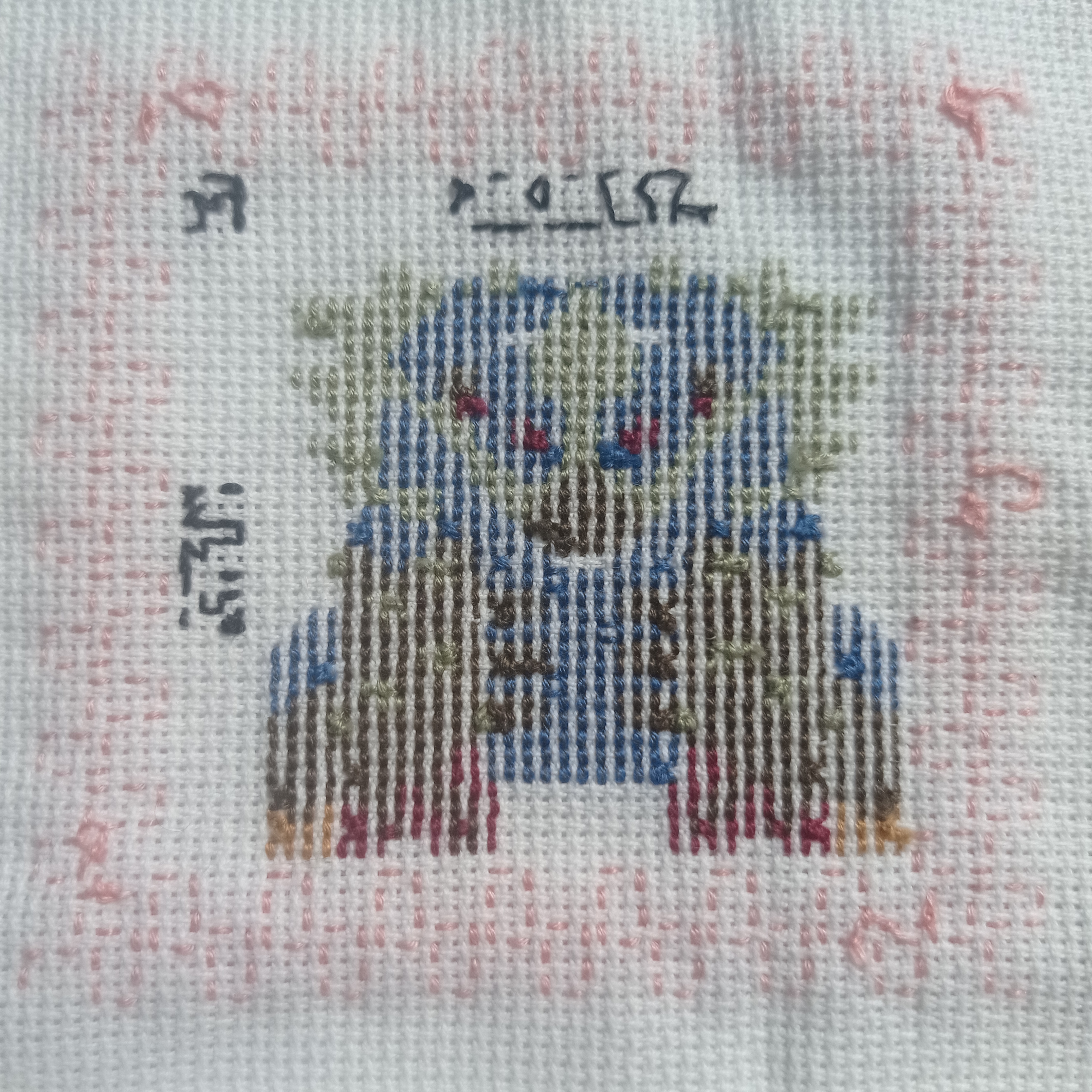 a closeup image of a crossstitch embroidery, showcasing a detailed design of a creature with blue, red, brown, and green threads. the background is white fabric, and the edges of the design are framed by pink stitching. the work shows the intricate detail of the crossstitching technique.