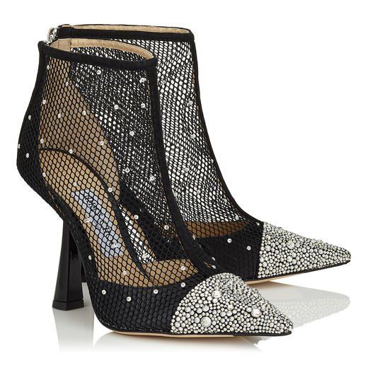 the image shows a pair of jimmy choo women's black mesh ankle booties. the booties are adorned with numerous small crystals or rhinestones, primarily concentrated on the toes. the mesh fabric is visible throughout the upper part of the shoe. they have a pointed toe and a high stiletto heel.  the shoes are elegantly styled and appear to be part of a luxury footwear collection.  the background is plain white, allowing the shoes to be the focal point.