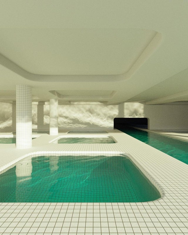 a large, modern swimming pool in a minimalist building. the pool is surrounded by white tile and the ceiling is also white. the pool is long and narrow, with a small section at the end that is deeper than the rest. the water is blue and still.