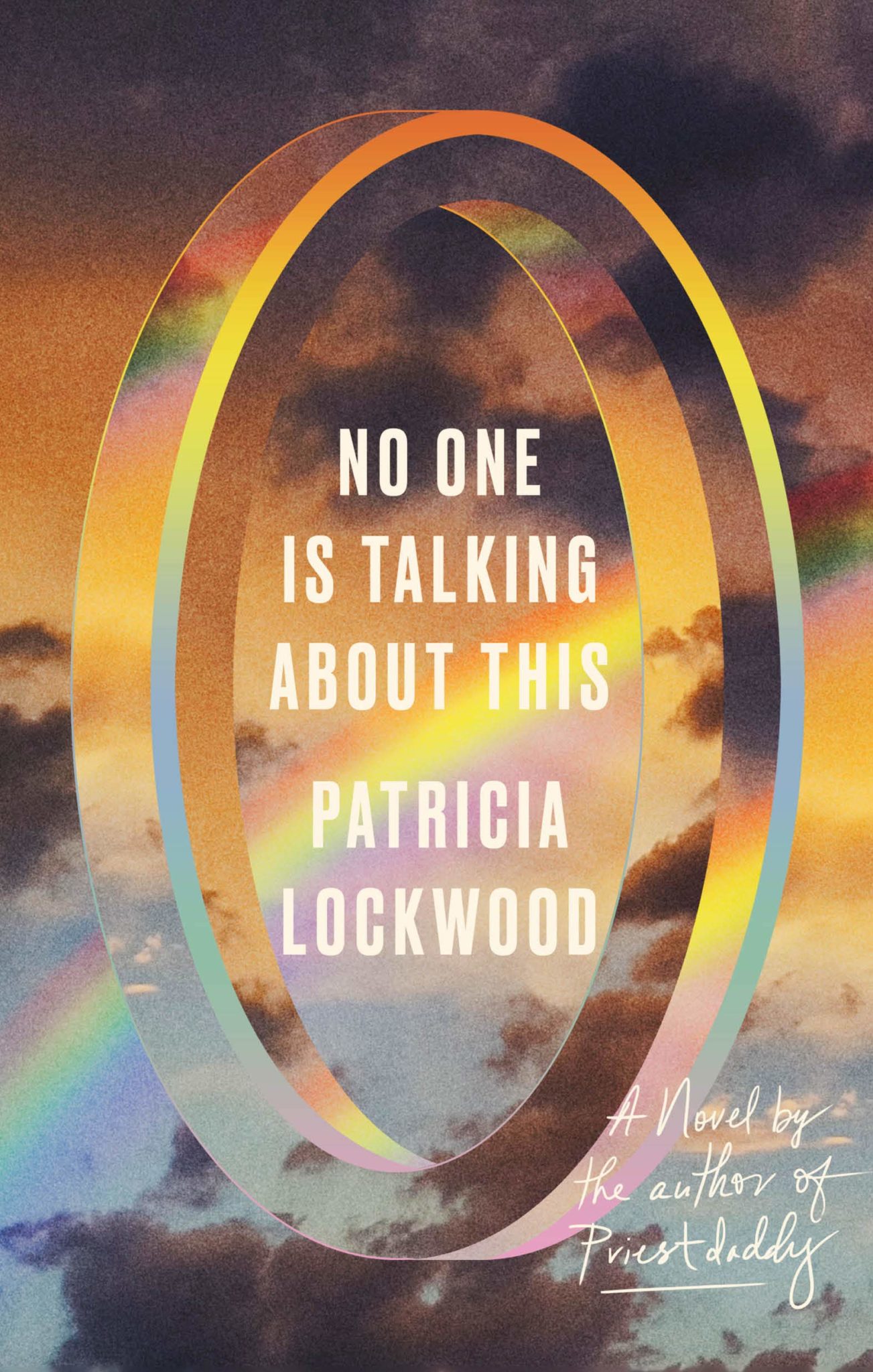 the image is a book cover for the novel "no one is talking about this" by patricia lockwood. the cover features a graphic design with a large rainbow ring overlayed on a background of clouds and a sky.  the book title and author's name are printed in white sansserif font within the ring. the lower right corner of the image features the text, "a novel by the author of priest daddy" written in black script. the overall design is colorful, abstract, and eyecatching.