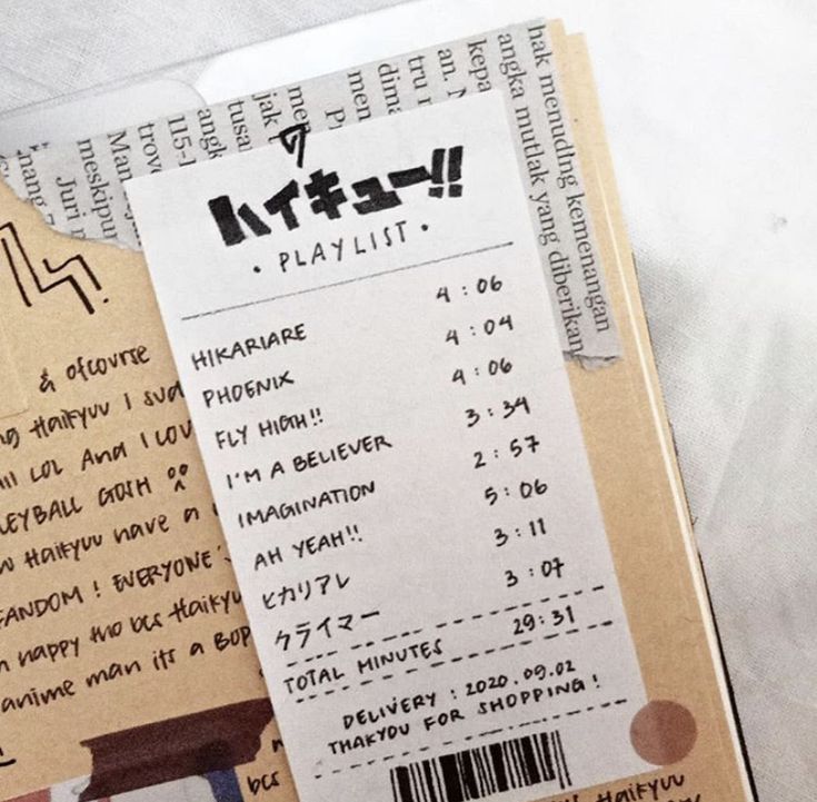 a closeup photo of a playlist titled "haikyuu!!" written in japanese. it looks like a receipt with times and the names of the songs on the playlist. the background is a notebook with an inscription about "hak menuding kemenangan" which is a phrase in the indonesian language.