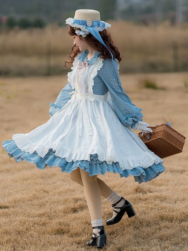 a woman in a blue and white lolita dress twirls in a field. she is wearing a straw hat and carrying a picnic basket. the dress is long and flowing, with layers of ruffles and lace. the field is green and brown, with a blue sky in the background.
