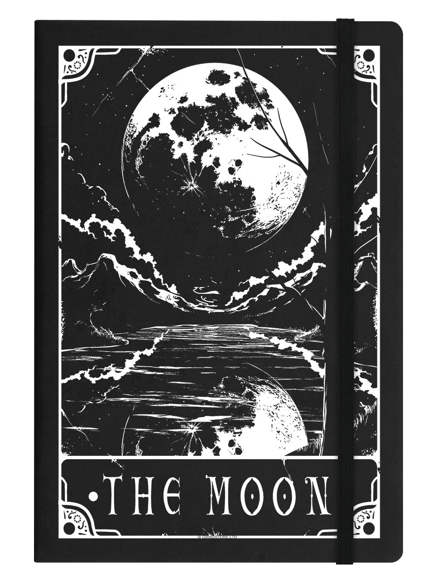 a black hardcover notebook featuring a stylized black and white illustration of a large full moon in the sky reflected in a body of water below. the illustration evokes a mystical and slightly eerie atmosphere. the words "the moon" are written in a decorative font at the bottom of the illustration. a black elastic band is wrapped vertically around the notebook.