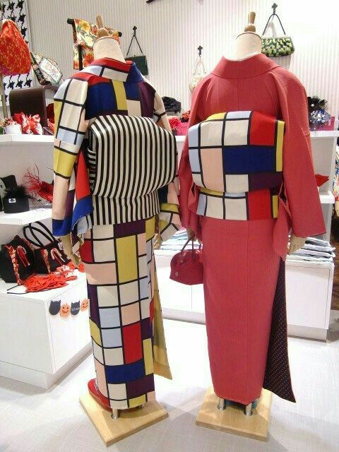 the image showcases two mannequins dressed in vividly designed kimonos, likely in a retail or display setting. the kimono on the left boasts a mondrianinspired pattern of colorful squares separated by black lines, paired with a bold blackandwhite striped obi. the kimono on the right is primarily red with a mondrianstyle obi. both mannequins are mounted on wooden stands, and various bags and accessories are visible on shelves in the background.