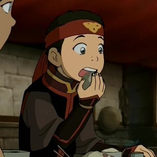 this is a still from the animated television series avatar: the last airbender. the image shows zuko, the prince of the fire nation, in profile. he has a surprised expression, and his mouth is open. he is holding a piece of food in his fingers, and appears to be about to take a bite. zuko is dressed in his fire nation uniform, which includes a red headband with the symbol of the fire nation. he is seated at a table. the image is animated, and the colors are vivid.
