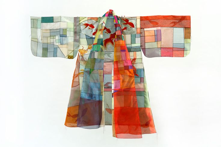 an image of a colorful, patchworkstyle kimono with a design featuring goldfish. the kimono is made of sheer fabrics and has an abstract, modern appearance. it is displayed against a white background.