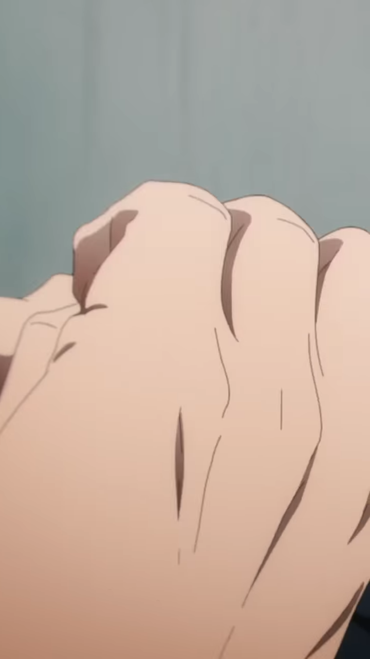 the image shows a closeup of a person's hand, tightly clenched into a fist. the focus on the details of the skin and wrinkles emphasizes the tension and strength conveyed by the gesture.