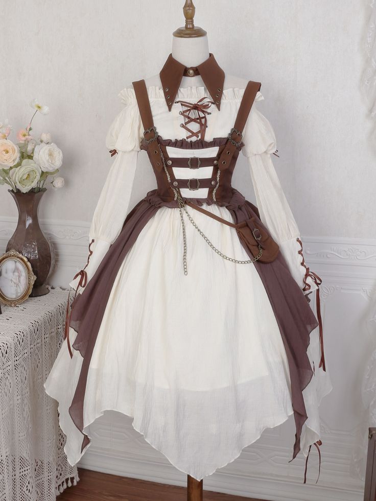 a creamcolored lolita dress with brown accents, displayed on a mannequin. the dress has a tiered skirt, long sleeves with lace detailing, and a brown faux leather corset with buckles and straps. the mannequin is positioned in front of a white wall with a side table visible on the left side of the image.