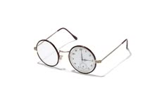 a pair of round glasses with one lens that is a clear watch face. the watch face lens is white with black hands and numbers. the other lens is clear. the glasses are silver and gold, and the frame is brown. the glasses are on a white background.