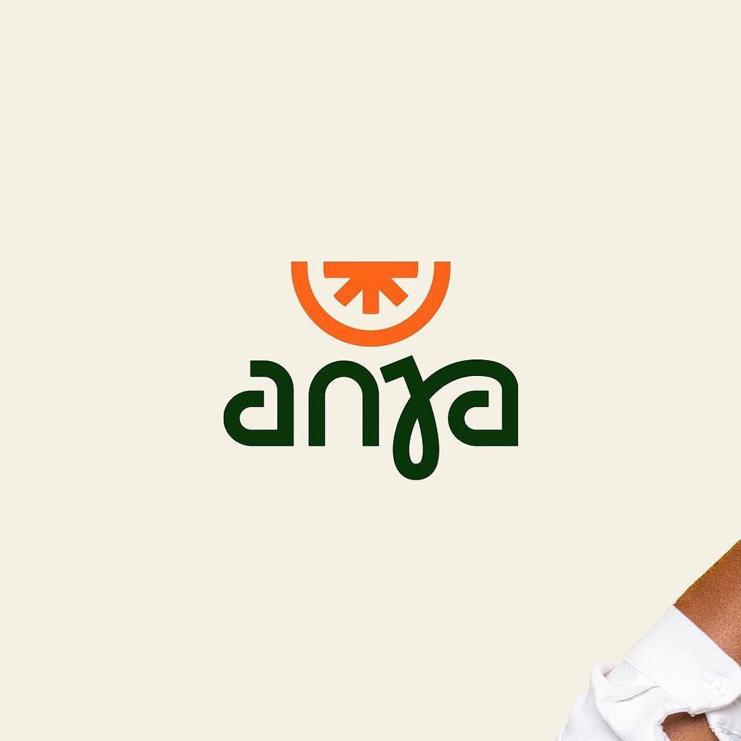 a logo design featuring a stylized orange slice above a wordmark. the wordmark appears to be in a nonlatin script. the background is a light beige.