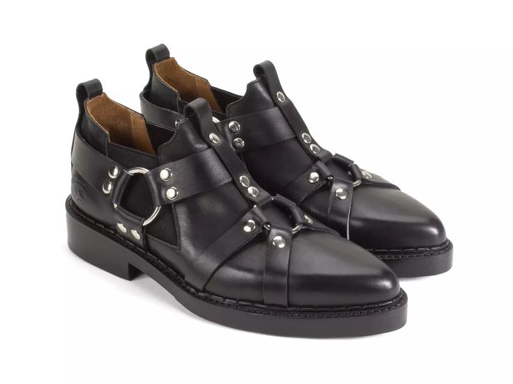 the image shows a pair of women's black leather ankle boots.  the boots have a pointed toe, a platform sole, and multiple buckles and studs as decorative accents.  they appear to be made of highquality leather and have a slightly grunge or rockerchic aesthetic. the boots are positioned slightly angled, one slightly overlapping the other.  the interior of the boots shows a light brown leather lining.