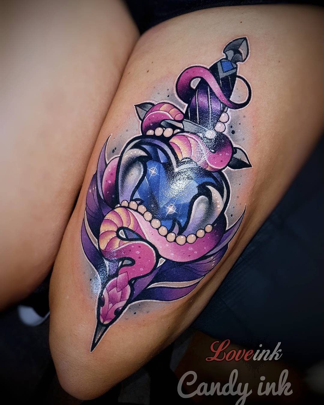 a thigh tattoo of a dagger piercing a heartshaped container with a snake wrapped around it.  the heart container is filled with a blue liquid and bubbles. the style is neo traditional.