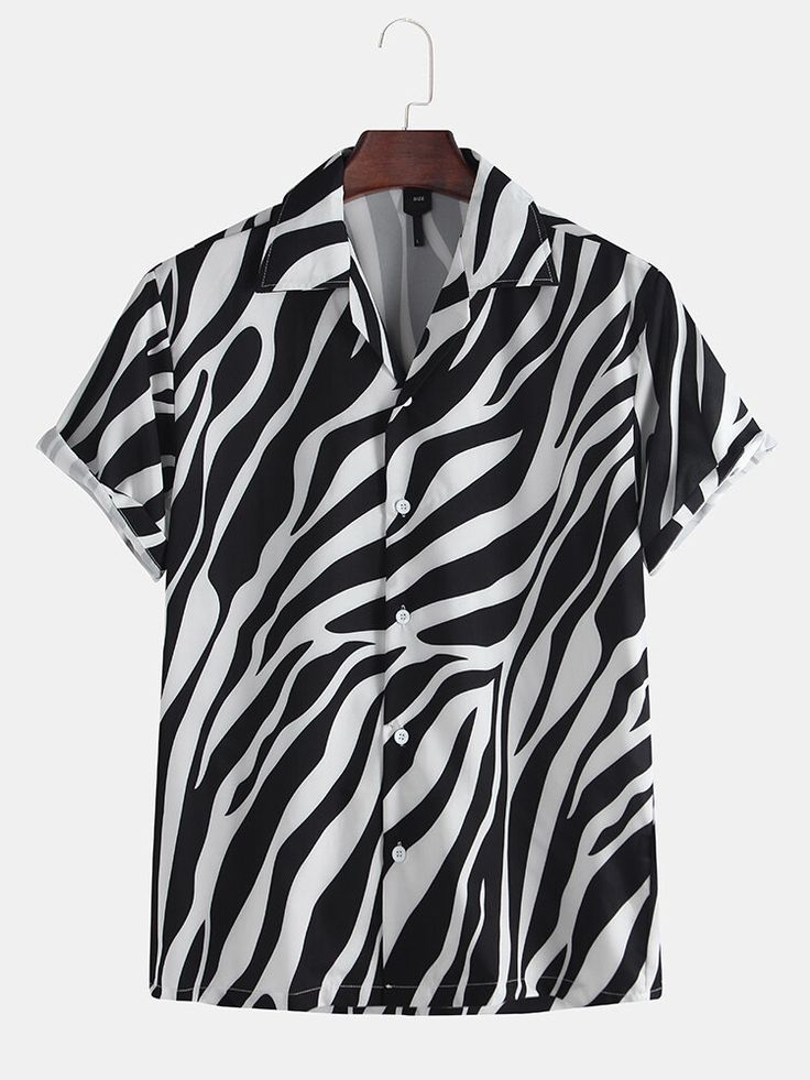 a black and white zebra print shortsleeve buttondown shirt hangs on a hanger against a neutral background. the shirt has a collared neck and is partially buttoned.