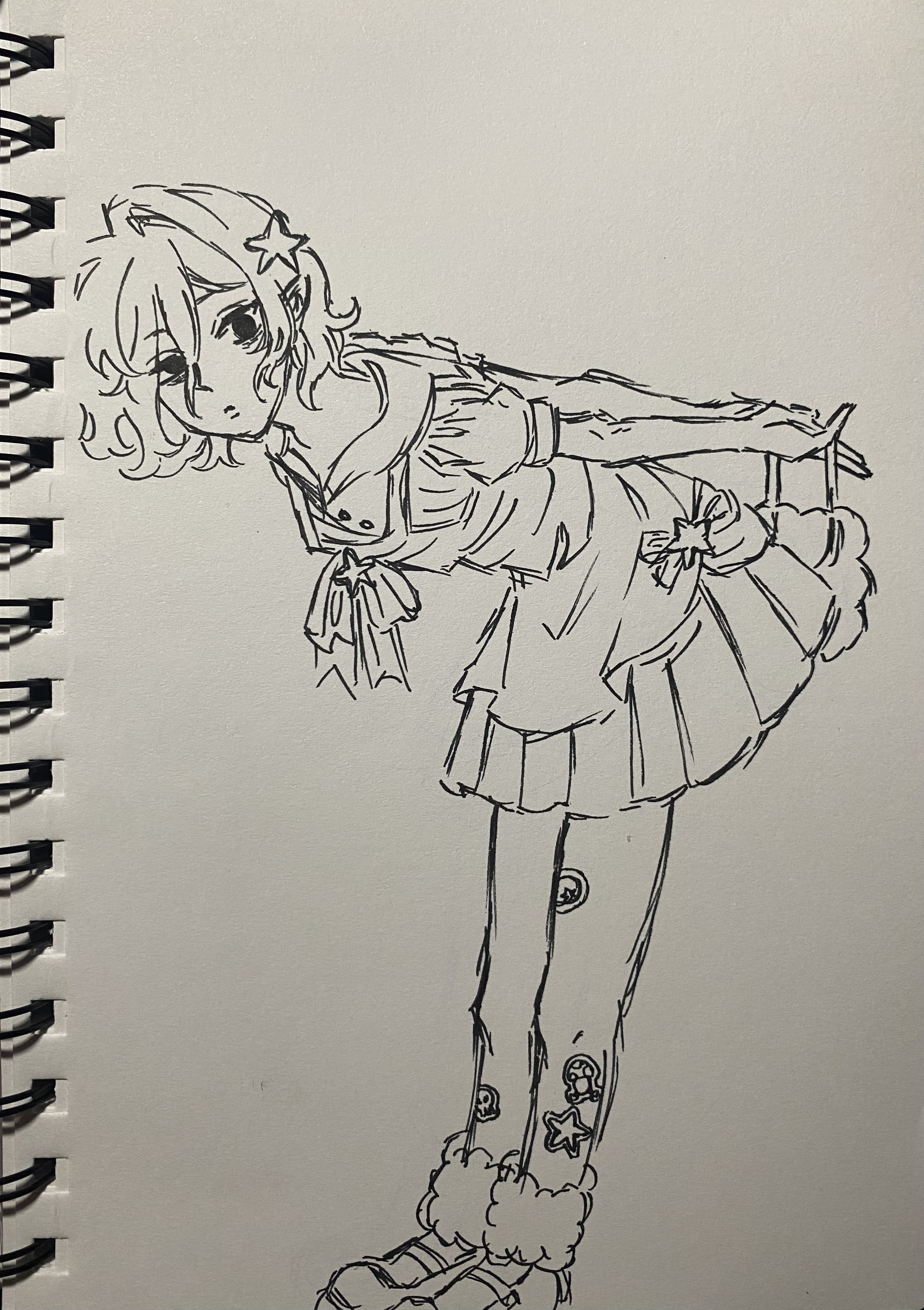 he image contains a sketch of an animestyle girl drawn in ink on a notebook page. the girl has curly hair, a sailorstyle top, a pleated skirt, and boots with fluffy accents. she's depicted in a playful, bending pose, with her arms extended and her head tilted. the style is reminiscent of manga or anime character design, with emphasis on linework and simple shading.  stars are visible as details on her clothing and hair.