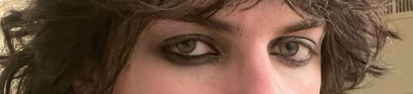 a portrait of a woman with brown hair, her face is close up and she is looking at the camera. she has brown eyes and the photo is taken from a close up angle.