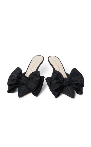 a pair of black heels with a bow on each shoe. the shoes are elegant and formal, and would be perfect for a party or other special occasion. the shoes are made by a designer and are likely expensive.