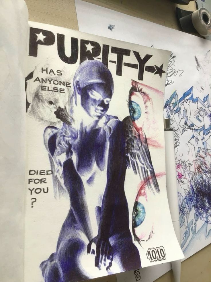 an art zine print or cover on a table. the art is done in shades of blue and depicts a nude woman with angel wings sitting in front of text that reads "purity. has anyone else died for you?".  there are also eyes collaged onto the print.