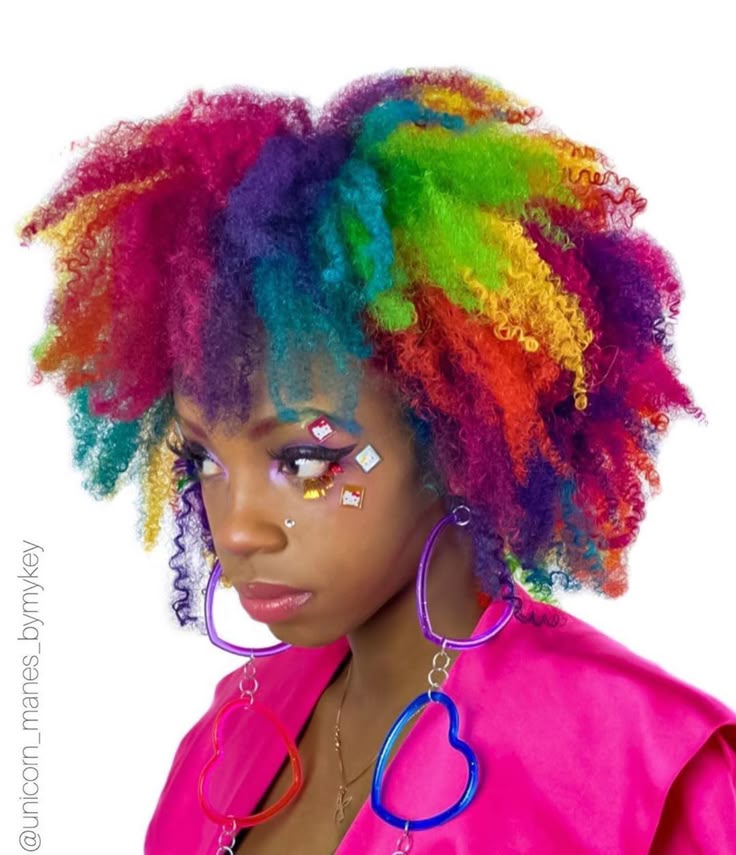 a portrait of a woman with curly, rainbowcolored hair. she has elaborate eye makeup and is wearing large, heartshaped earrings. she also has a nose piercing and stickers on her face, including hello kitty stickers. she is wearing a bright pink jacket. the image is vibrant and colorful.