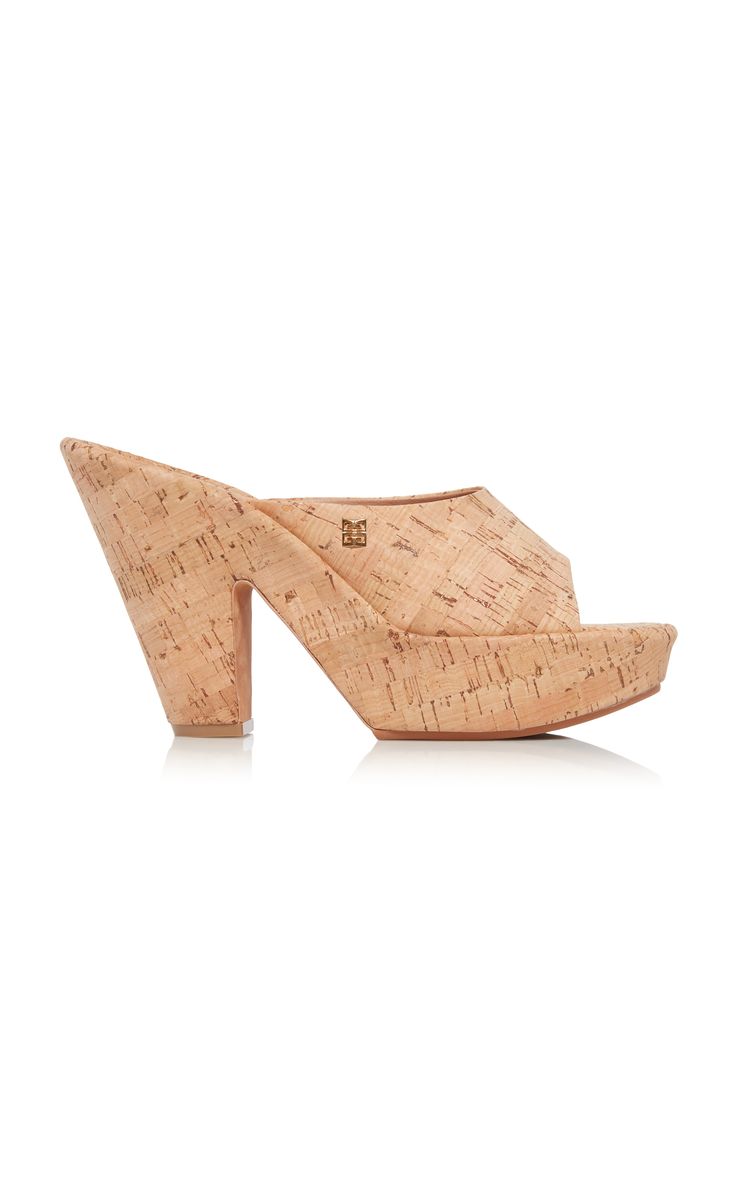 a pair of women's cork mules with a platform wedge heel. the shoes are a light beige color and have a slightly pointed toe. they are shown on a white background.