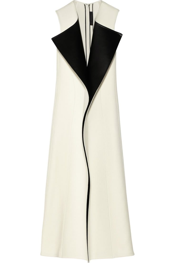 a long, sleeveless cream dress with a black collar that extends down the front.