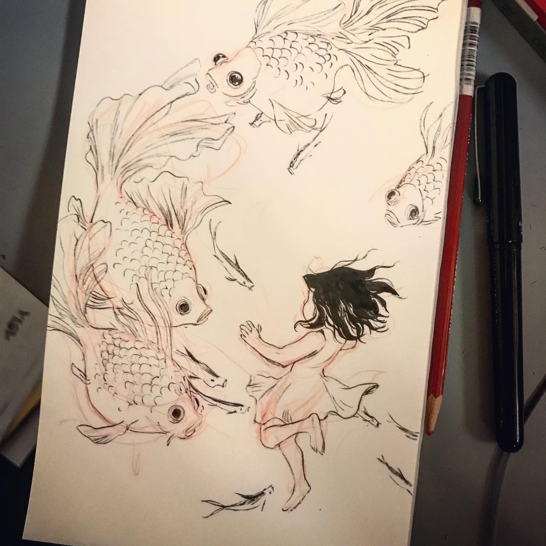 a sketchbook drawing shows a young girl in a dress with wavy hair surrounded by several goldfish swimming in different directions. there are doodles of smaller fish around the girl's feet, suggesting she might be in the water with them. a red pencil and a black pen rest along the right edge of the open sketchbook. the style is whimsical and reminiscent of a fantasy scene.