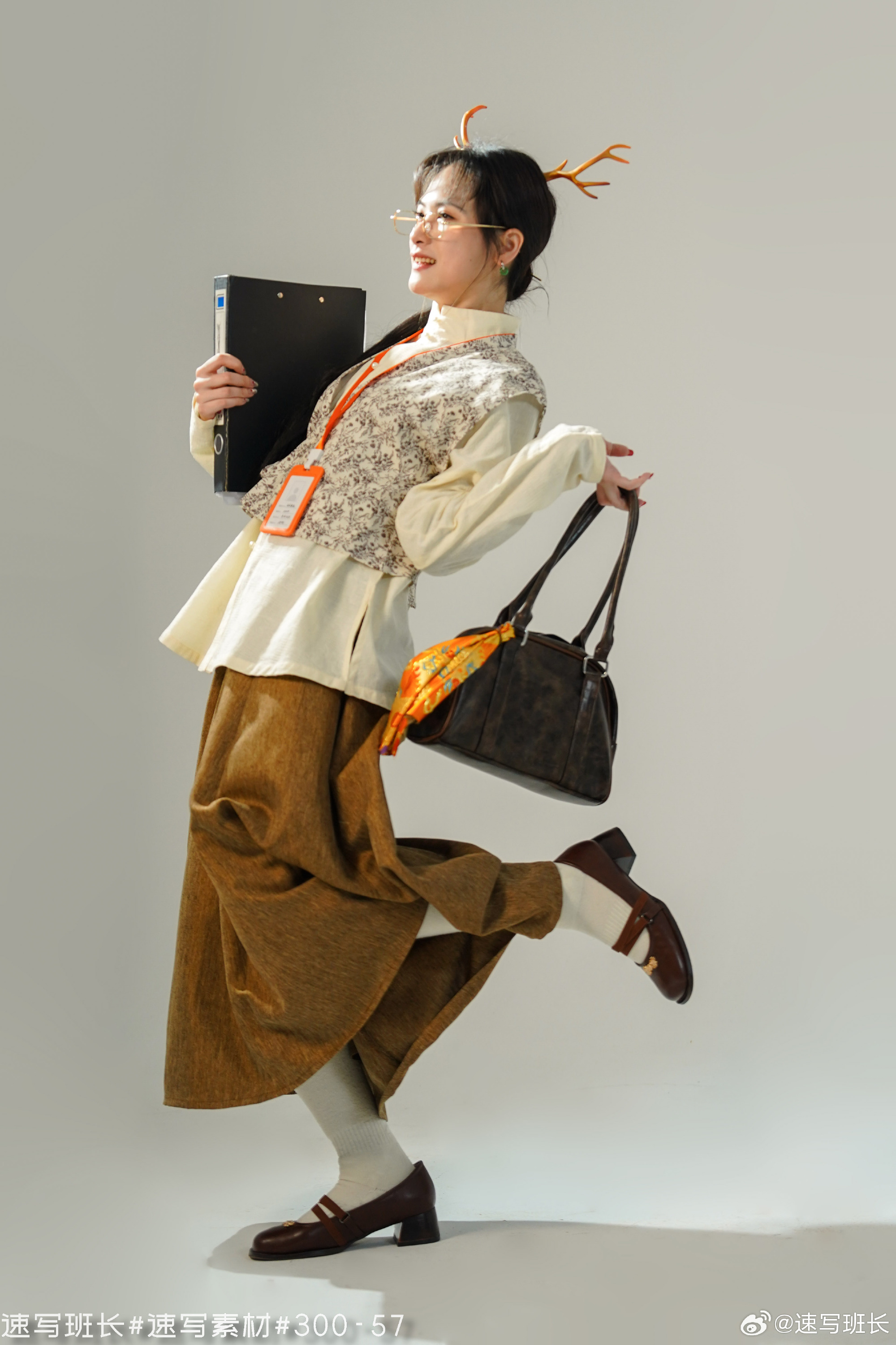 a chinese woman wearing a deer headband stands on a white background. she is dressed in office attire, holding a file folder and a brown bag. the image has a warm, artificial light.