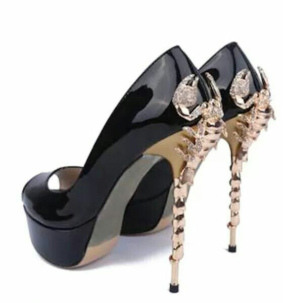 a pair of black patent leather high heels with a peep toe. the heels are adorned with gold scorpion detailing on the heels. the shoes are platform heels and have a stiletto heel. they are positioned to show both the side and back view. the shoes appear to be luxurious and elegant, suitable for a party or special occasion.