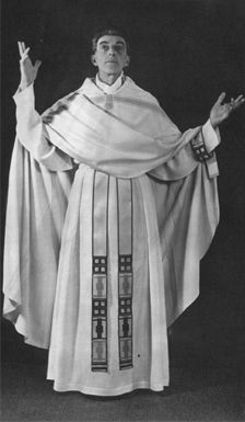 a man in a white robe with black accents is standing in a formal pose with his arms raised. his pose is reminiscent of a priest or religious figure.  the image is black and white, creating a sense of solemnity and reverence.