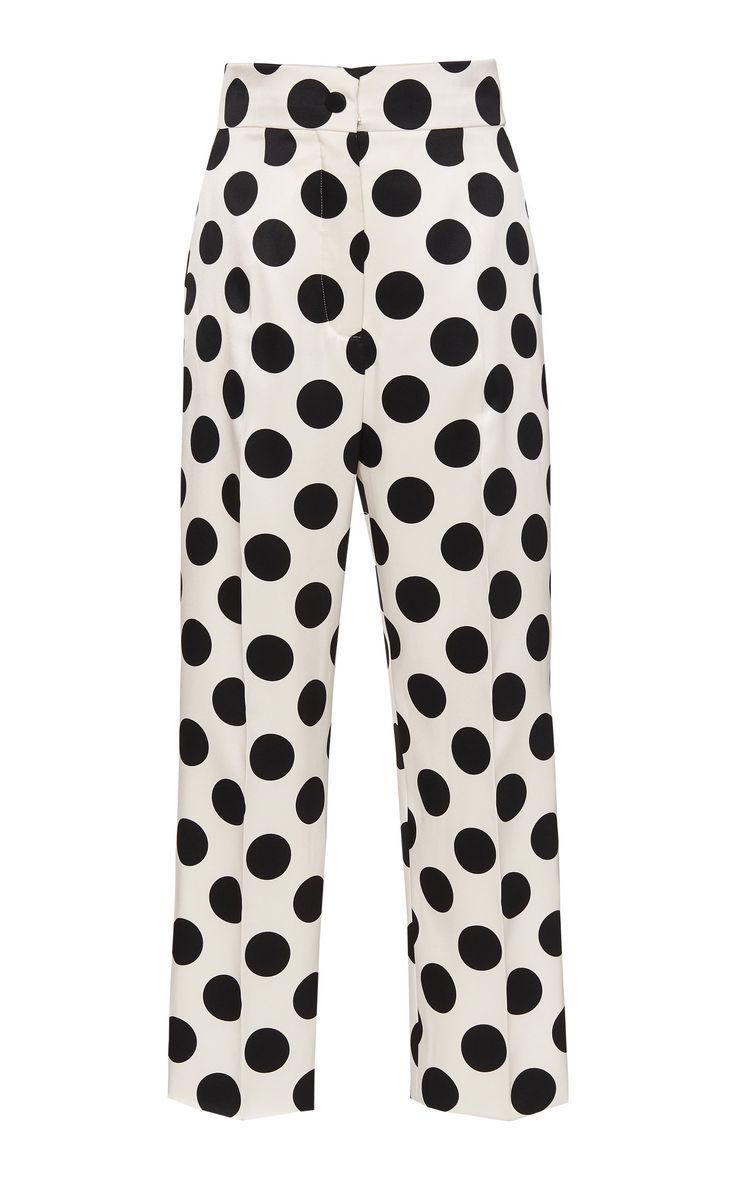 a pair of highwaisted white pants with large black polka dots. the pants are a slim fit with a straight leg. they have a classic, elegant style that is perfect for any occasion.