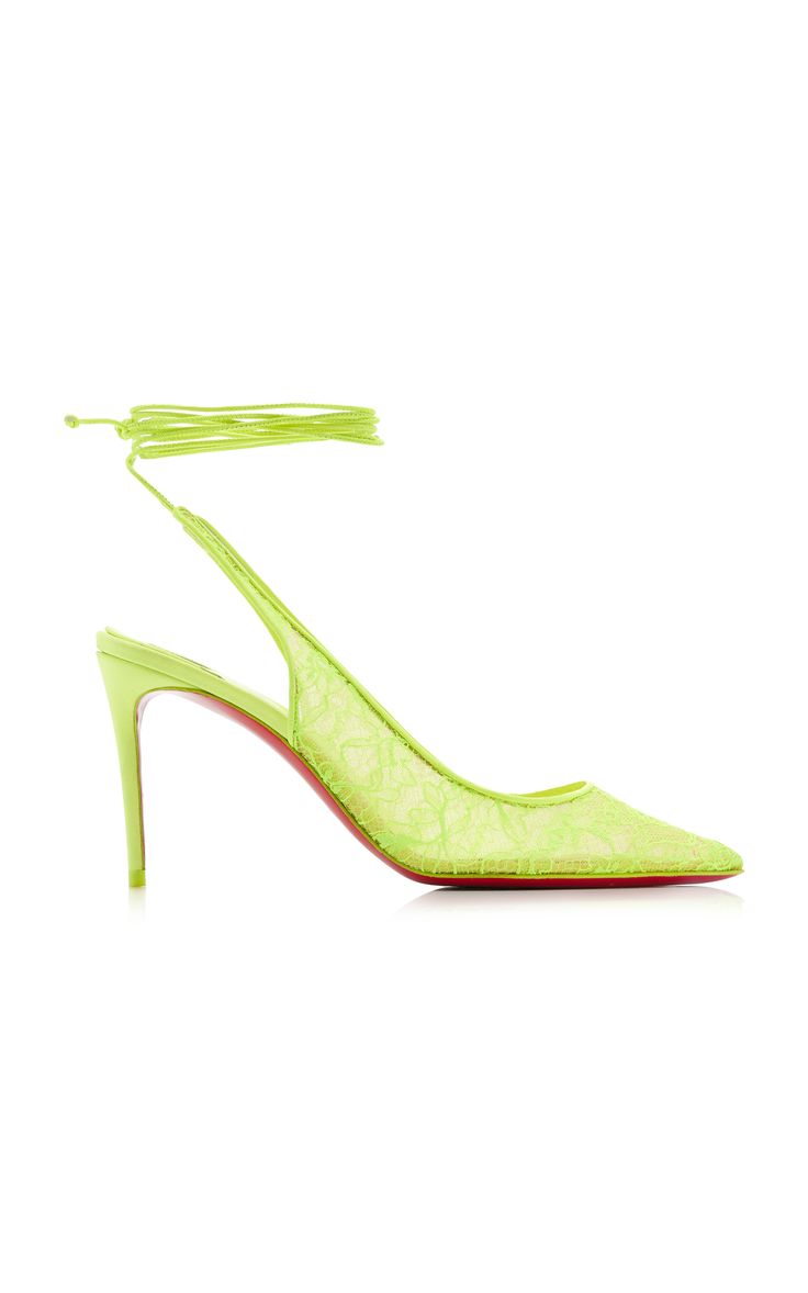 a pair of bright neon yellow highheeled shoes are shown in the image. the shoes are made of lacy material and have a thin stiletto heel.  the shoes have a single strap that goes around the ankle and ties in the front.  the shoes are posed on a white background.