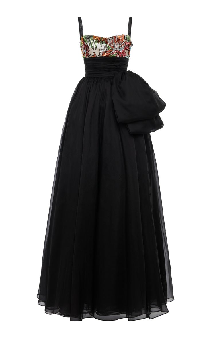 a long black chiffon gown with spaghetti straps and a floral print bodice. the gown has a large bow at the waist.