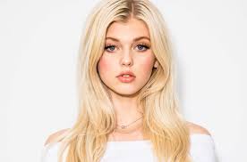 a portrait of loren gray, a young woman with blonde hair, blue eyes, and light skin. she is wearing makeup, a white top, and a necklace. she is an influencer, model, and celebrity.