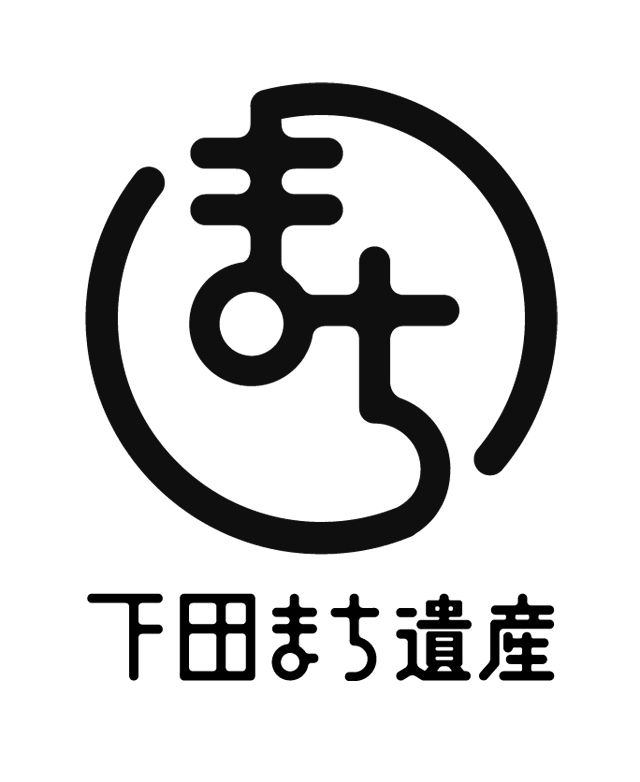 the image contains a japanese logo with a black and white design. it features a stylized character in a circle with a japanese text below it. the character consists of lines and a circle, creating a minimalist abstract design. the text below the character is "下田まち道康," which is written in japanese characters. the logo likely represents a japanese restaurant, business, or brand associated with health and wellness. the overall design is modern and simple, with a focus on the character as the central element.