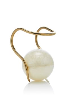 this is a closeup image of a gold ring with a large pearl. the ring is simple and delicate, with a smooth gold band that wraps around the pearl. the pearl is white and has a smooth surface. the ring is a beautiful piece of jewelry that would be perfect for any occasion.
