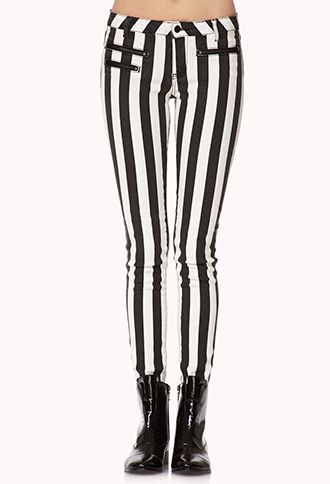 a closeup shot of a woman's lower body showcasing a pair of black and white vertically striped skinny jeans paired with black ankle boots.  the model is wearing the jeans, which are the main focus of the image, with the boots adding to the overall style. the background is plain white, making the pants the clear subject.