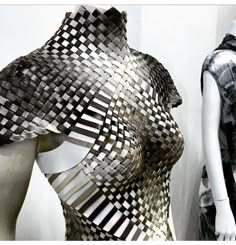 a closeup image of a striking black and white woven dress. the intricate geometric pattern creates a mesmerizing and abstract effect. the dress is a bold and stylish piece that would make a statement at any event.