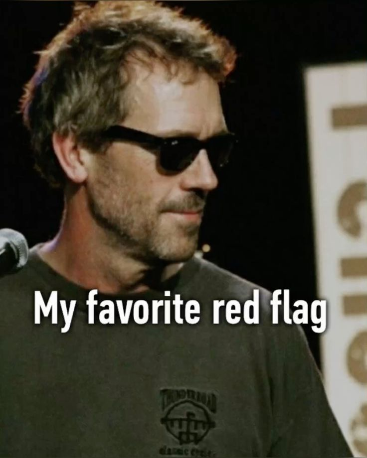 the image shows actor hugh laurie wearing sunglasses and a tshirt with text overlay "my favorite red flag". it appears to be a meme format.