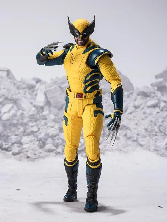a wolverine action figure stands in an attack pose against a white background with artificial snow and debris. the figure is highly detailed and features his classic yellow and blue costume, complete with his signature claws. the lighting is bright and highlights the figure's details, while the perspective gives the viewer a clear view of the action figure.