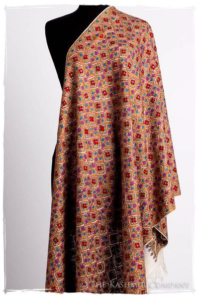 a brown shawl with a floral and paisley pattern is draped over a mannequin.