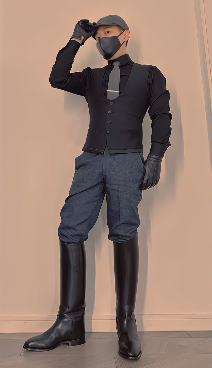 a man wearing a black hat, black leather gloves, black tie, a black vest, and a pair of black leather boots is standing in front of a white wall, looking away from the camera. he's wearing a formal and stylish outfit.