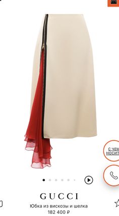 this is a product photo of a gucci skirt. the skirt is white and has a red, ruffled accent that extends down the left side. it looks to be made of a silky, soft material. the skirt is on a white background. the brand logo is at the bottom.